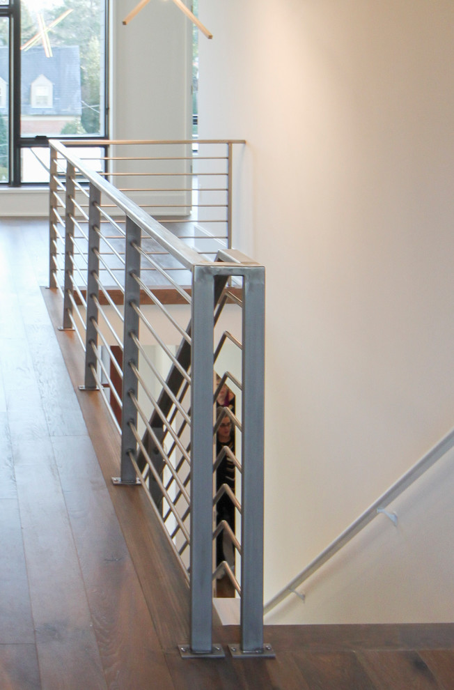 Modelo de escalera suspendida contemporánea grande con escalones de madera y barandilla de metal
