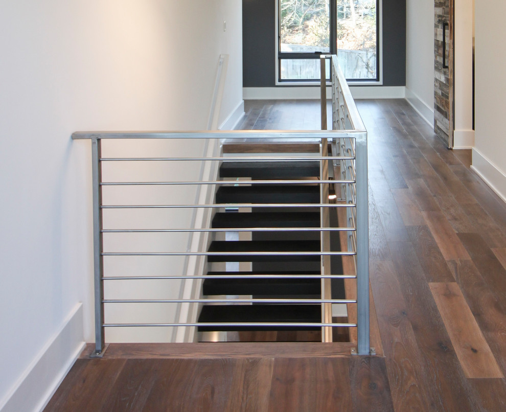 Modelo de escalera suspendida contemporánea grande con escalones de madera y barandilla de metal
