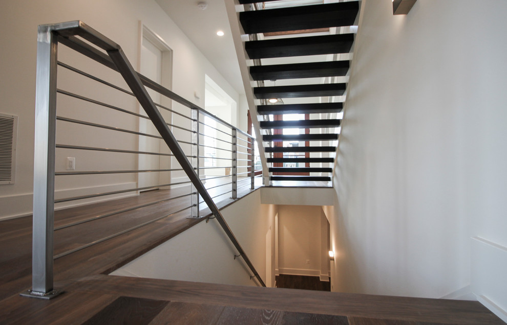 На фото: большая лестница на больцах в современном стиле с деревянными ступенями и металлическими перилами с