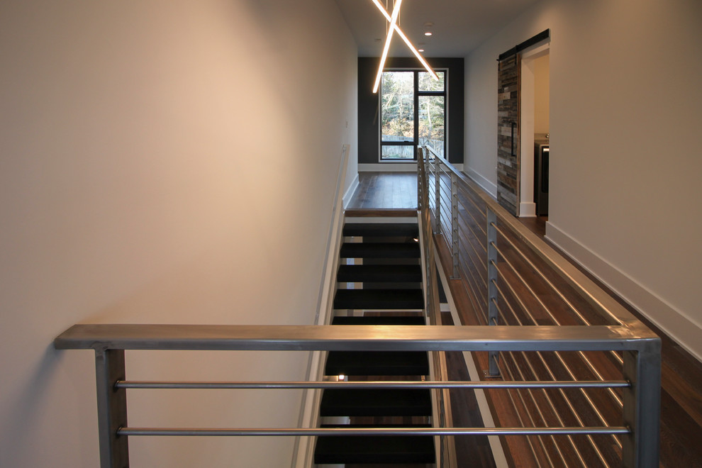 Идея дизайна: большая лестница на больцах в современном стиле с деревянными ступенями и металлическими перилами