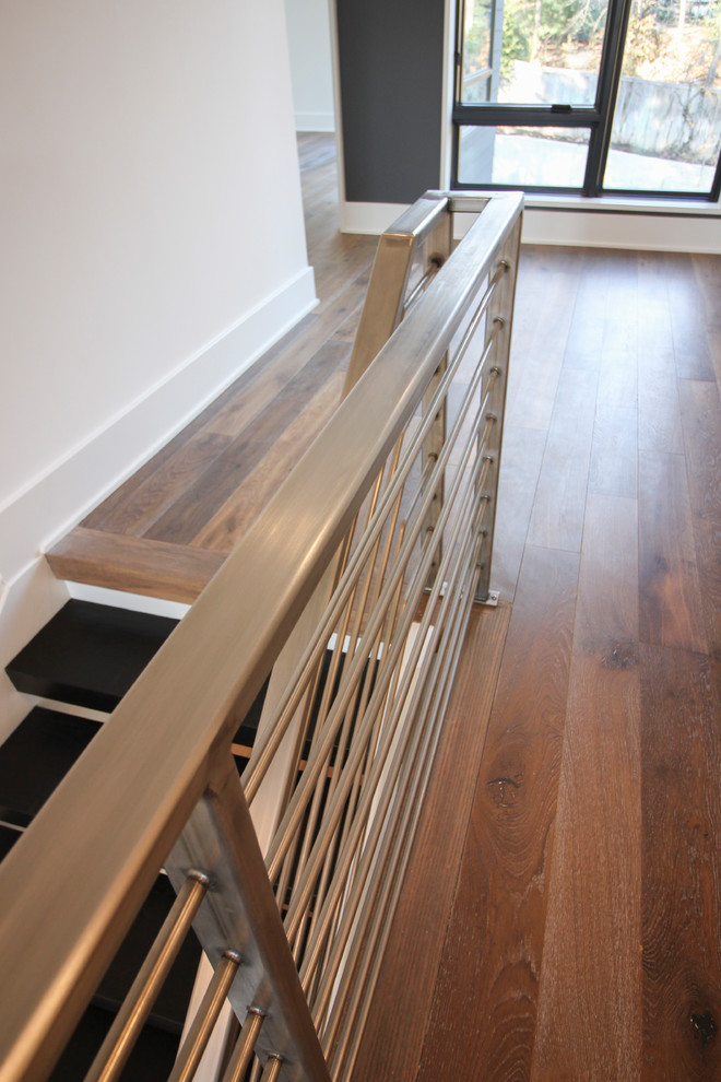 Inspiration pour un grand escalier flottant design avec des marches en bois et un garde-corps en métal.