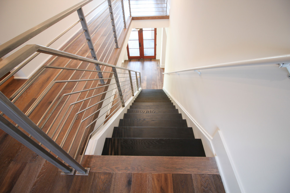 Стильный дизайн: большая лестница на больцах в современном стиле с деревянными ступенями и металлическими перилами - последний тренд