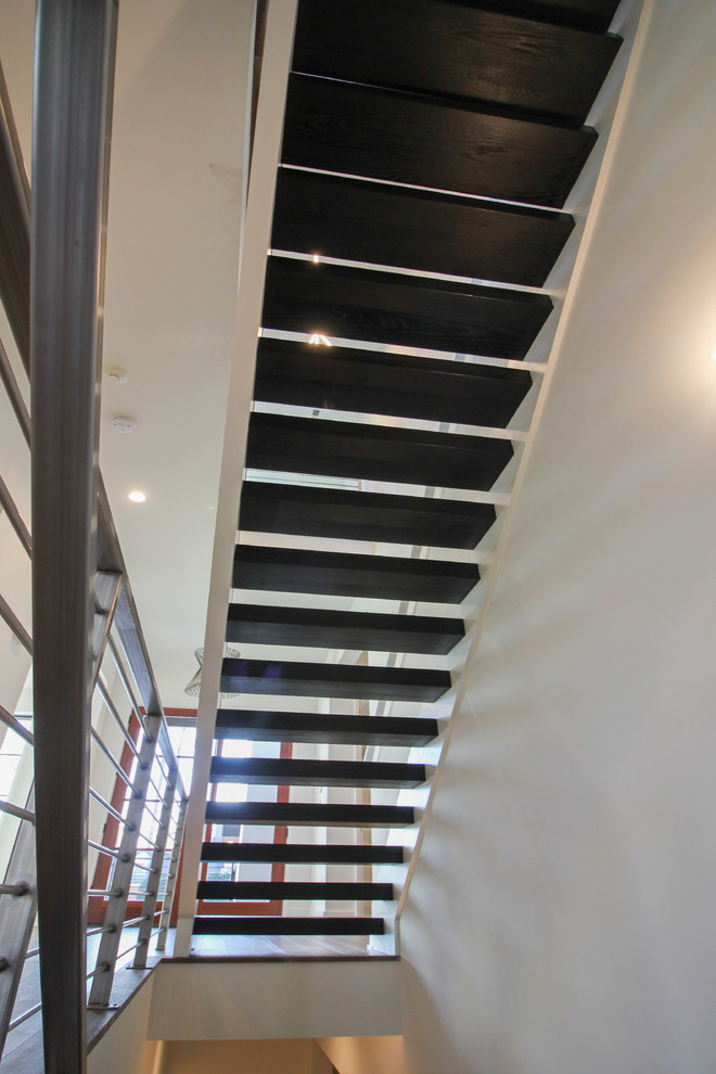 Photo of a large contemporary wood floating metal railing staircase in DC Metro.