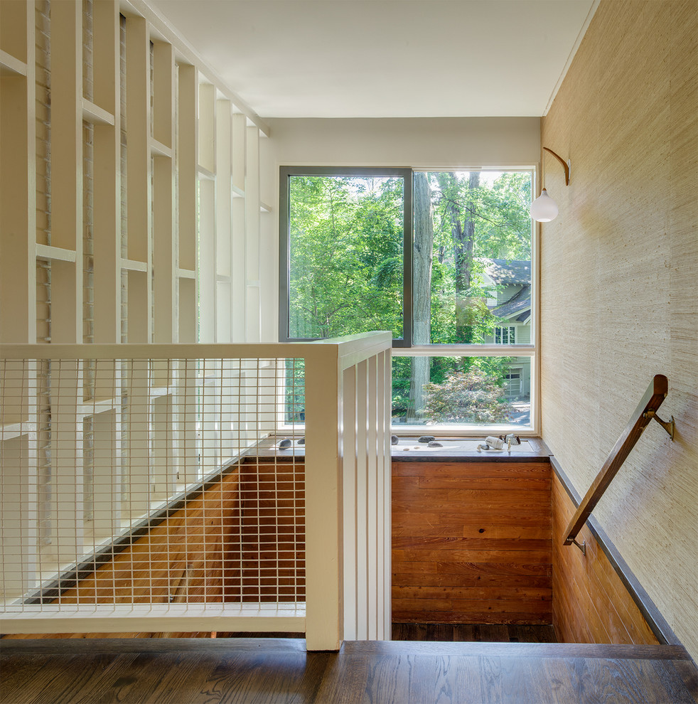 Пример оригинального дизайна: большая п-образная лестница в стиле ретро с деревянными ступенями и крашенными деревянными подступенками