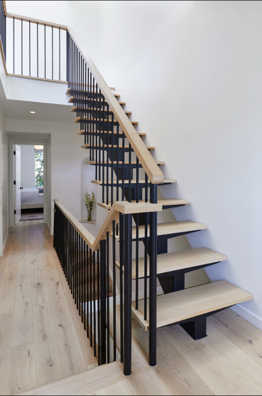 Ejemplo de escalera suspendida actual grande sin contrahuella con escalones de madera y barandilla de madera