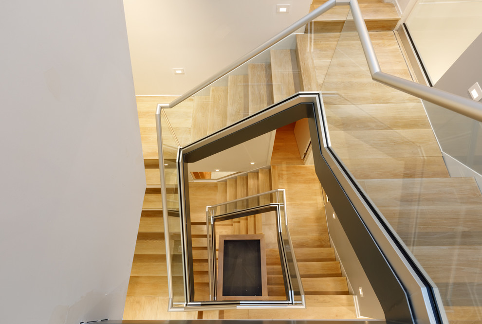 Diseño de escalera contemporánea con escalones de madera, contrahuellas de madera y barandilla de metal