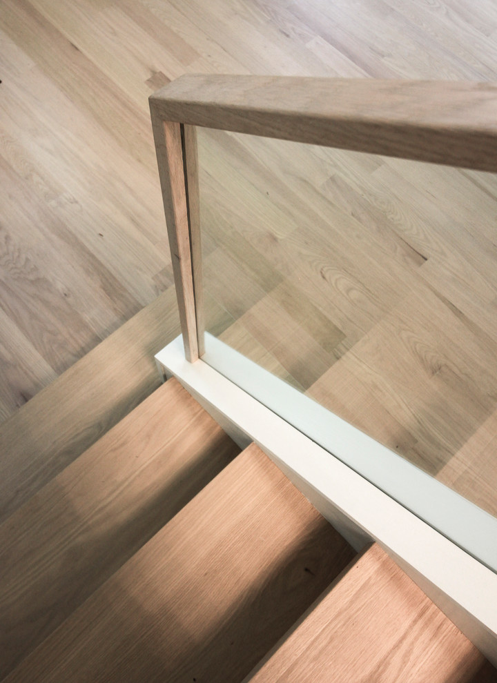 Immagine di una piccola scala a rampa dritta contemporanea con pedata in legno, alzata in legno e parapetto in vetro