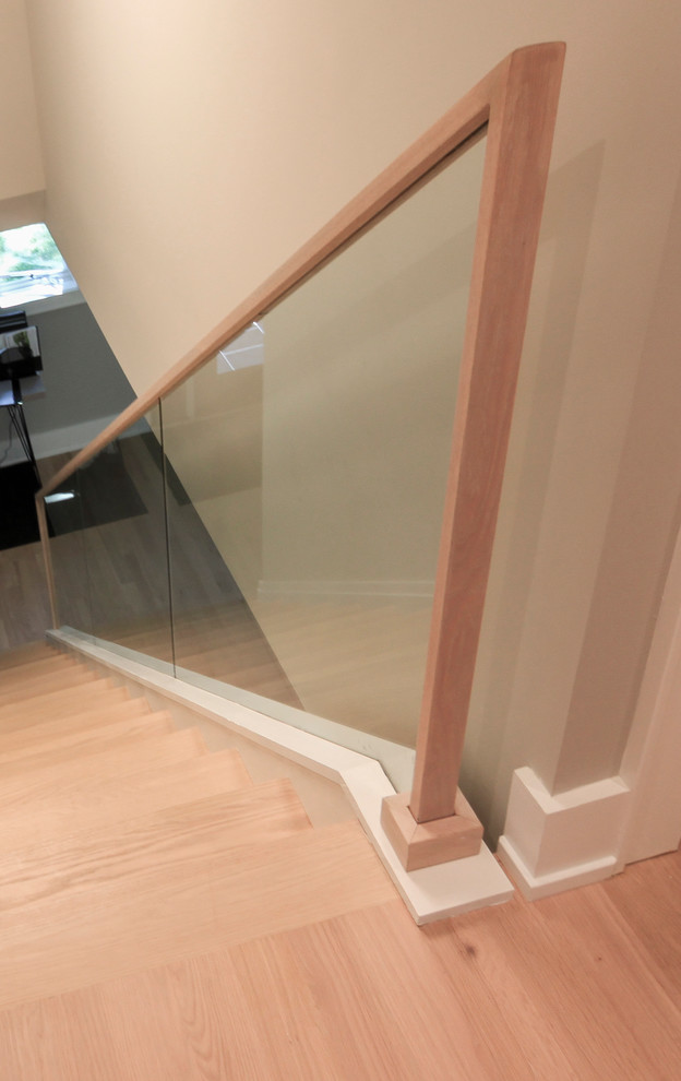 Cette photo montre un petit escalier droit tendance avec des marches en bois, des contremarches en bois et un garde-corps en verre.