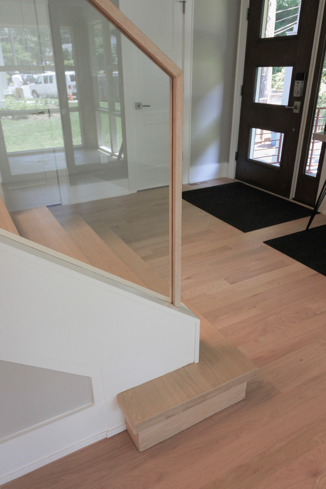 Foto de escalera recta contemporánea pequeña con escalones de madera, contrahuellas de madera y barandilla de vidrio
