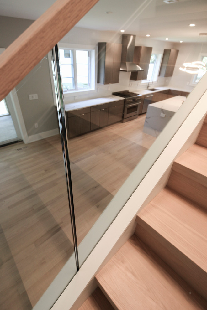 Ejemplo de escalera recta actual pequeña con escalones de madera, contrahuellas de madera y barandilla de vidrio