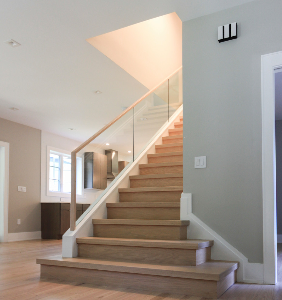 Ejemplo de escalera recta contemporánea pequeña con escalones de madera, contrahuellas de madera y barandilla de vidrio