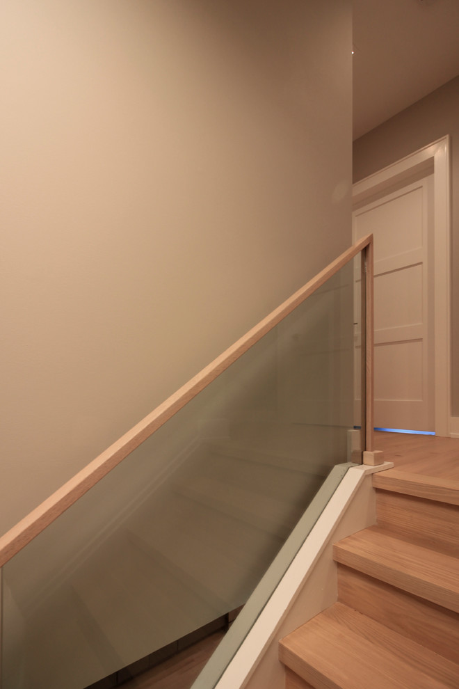 Ejemplo de escalera recta actual pequeña con escalones de madera, contrahuellas de madera y barandilla de vidrio