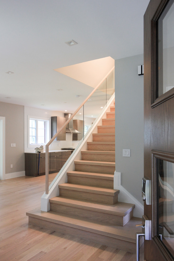 Imagen de escalera recta actual pequeña con escalones de madera, contrahuellas de madera y barandilla de vidrio
