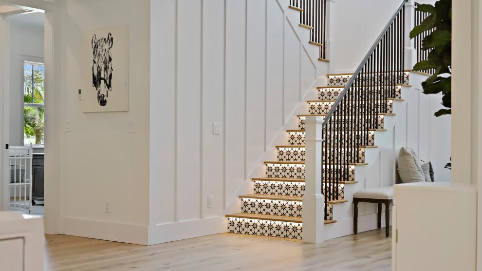 Идея дизайна: большая п-образная лестница в стиле неоклассика (современная классика) с деревянными ступенями, подступенками из плитки и металлическими перилами