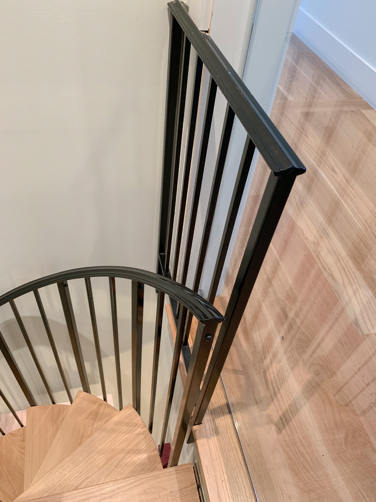 Small contemporary wood spiral metal railing staircase in DC Metro.