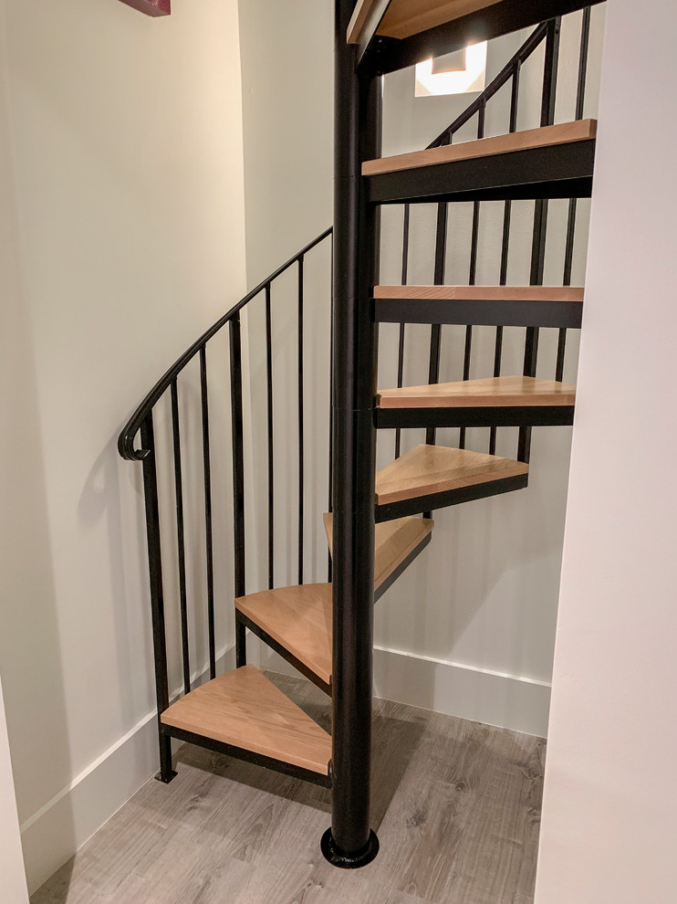 Foto de escalera de caracol actual pequeña con escalones de madera y barandilla de metal