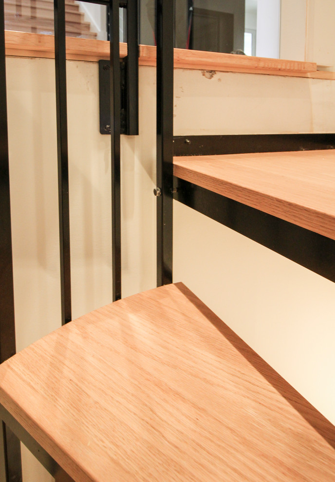 Ejemplo de escalera de caracol actual pequeña con escalones de madera y barandilla de metal