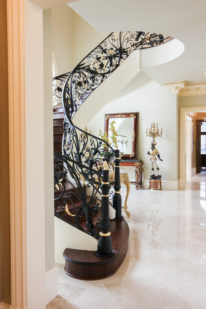 Inspiration for a huge timeless wooden curved metal railing staircase remodel in DC Metro with wooden risers