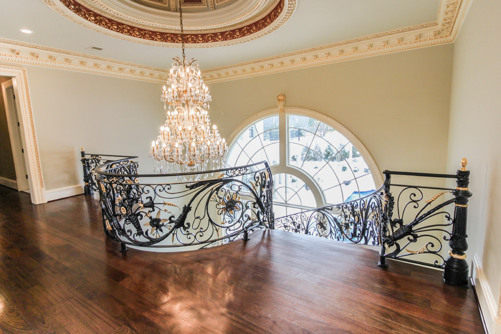 Inspiration for an expansive classic wood curved metal railing staircase in DC Metro with wood risers.