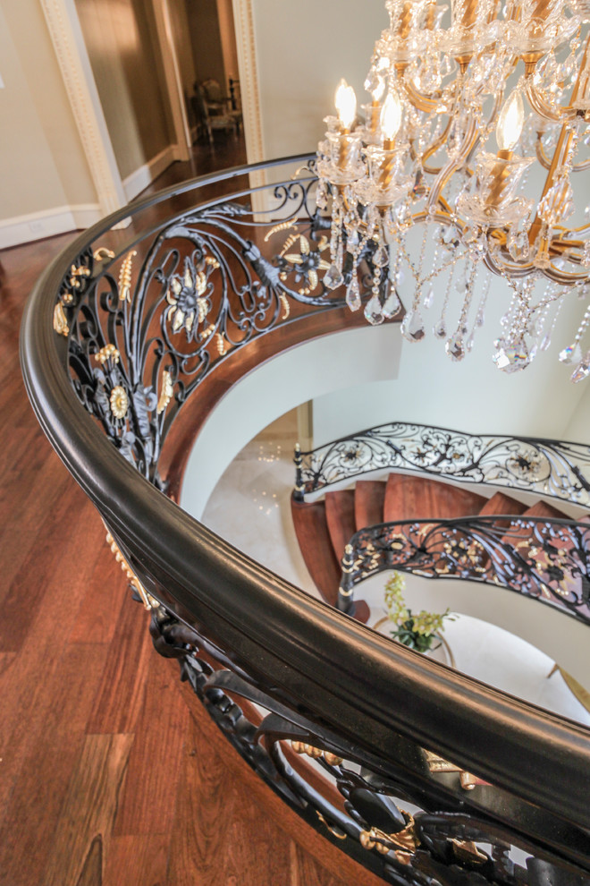Staircase - huge traditional wooden curved metal railing staircase idea in DC Metro with wooden risers