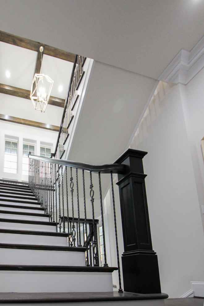 Imagen de escalera suspendida clásica renovada grande con escalones de madera, contrahuellas de madera y barandilla de vidrio