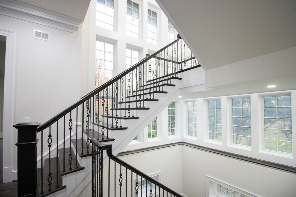 Example of a large transitional wooden floating glass railing staircase design in DC Metro with wooden risers