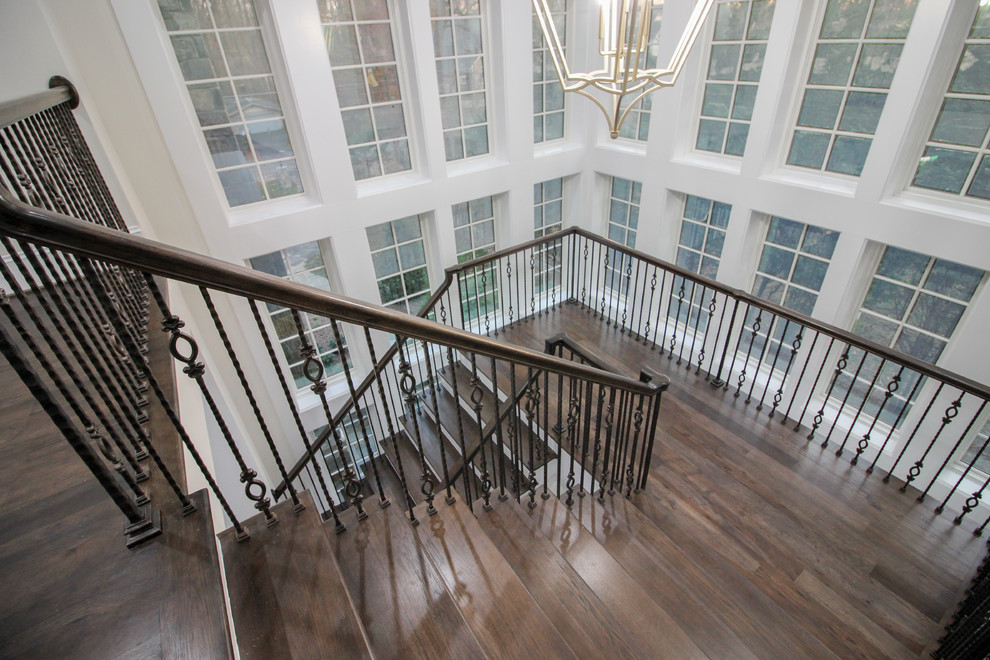 Example of a large transitional wooden floating glass railing staircase design in DC Metro with wooden risers