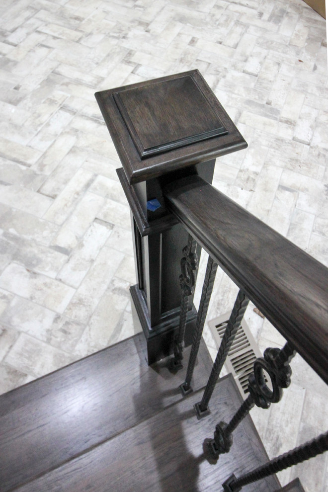 Пример оригинального дизайна: большая деревянная лестница на больцах в стиле неоклассика (современная классика) с деревянными ступенями и стеклянными перилами