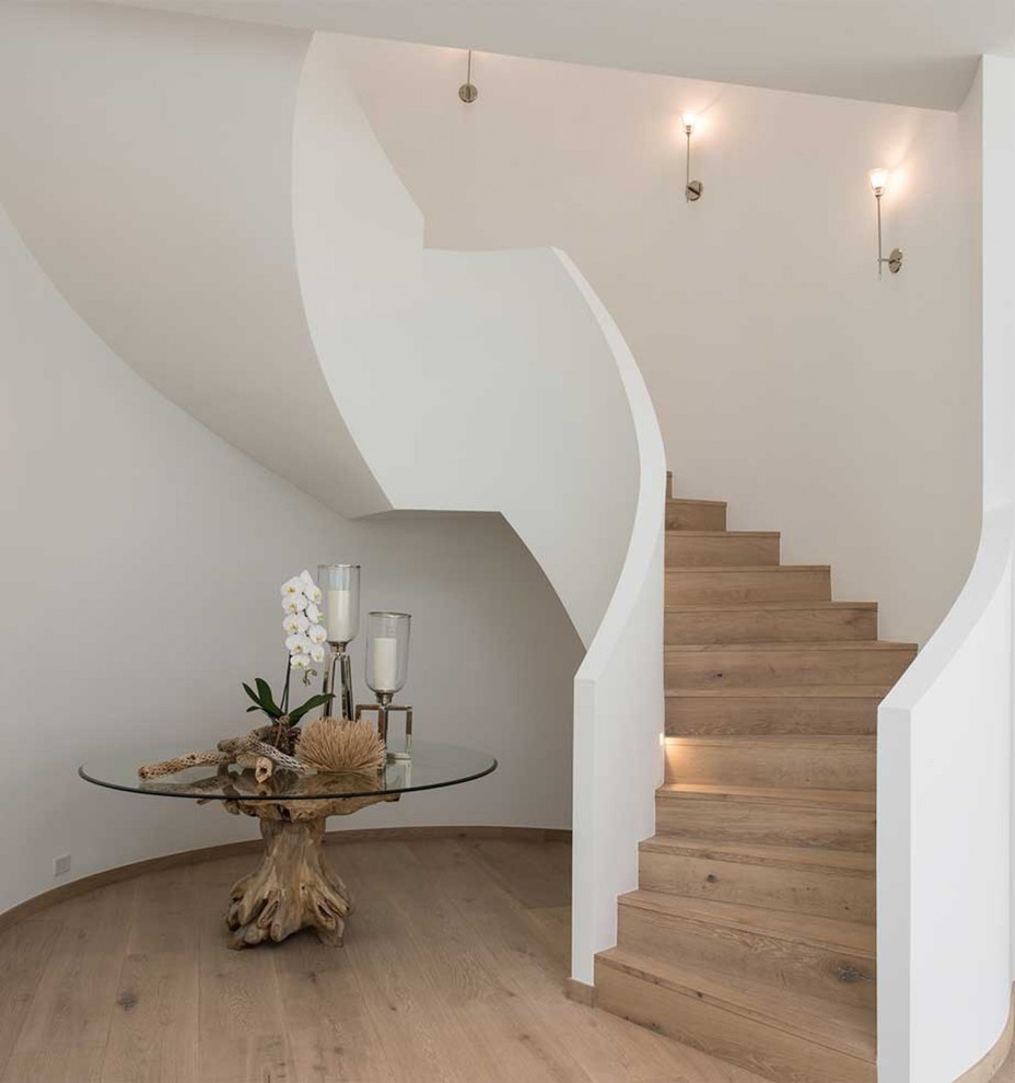 Cette image montre un escalier courbe design avec des marches en bois et des contremarches en bois.