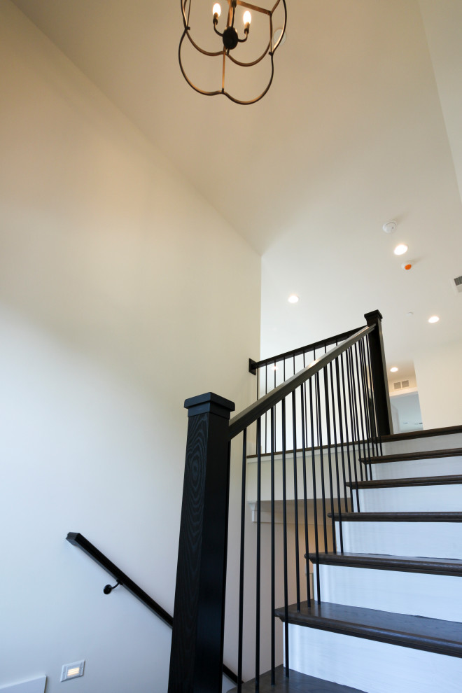 Idée de décoration pour un escalier design en U de taille moyenne avec des marches en bois, des contremarches en bois et un garde-corps en métal.