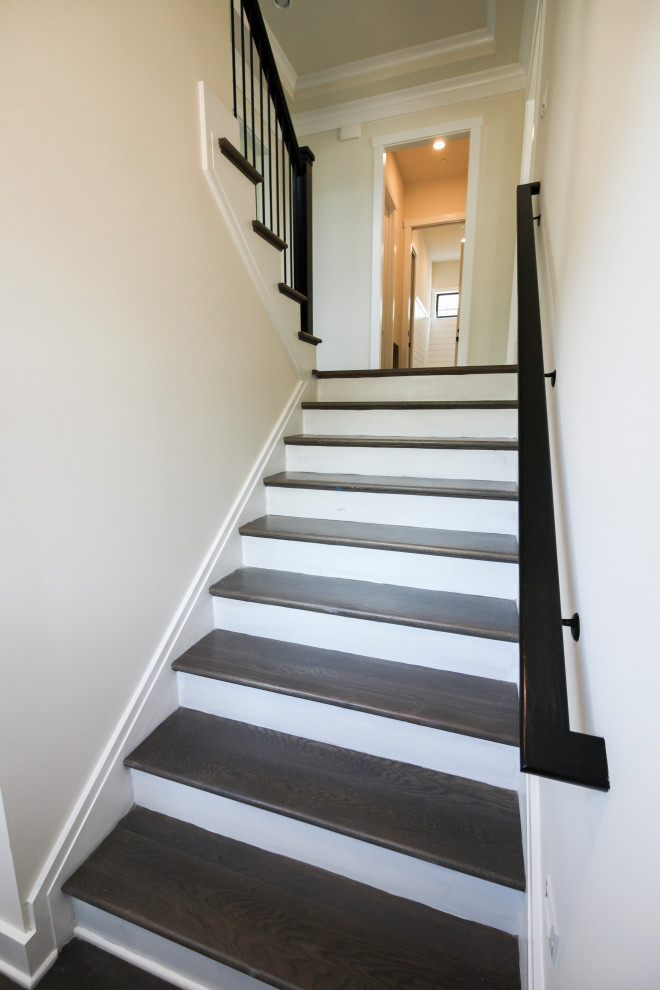Medium sized contemporary wood u-shaped metal railing staircase in DC Metro with wood risers.