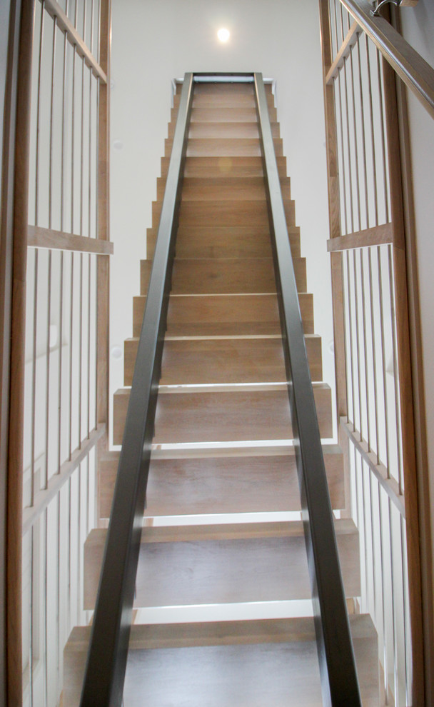 Ejemplo de escalera suspendida contemporánea de tamaño medio con escalones de madera y barandilla de metal