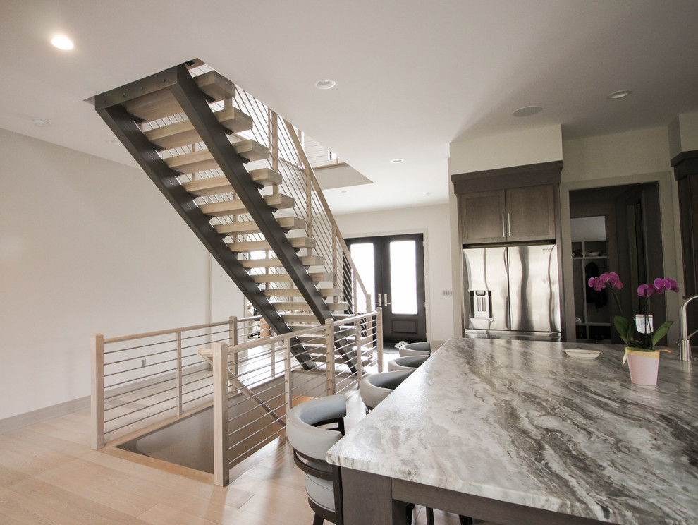 Ejemplo de escalera suspendida contemporánea de tamaño medio con escalones de madera y barandilla de metal
