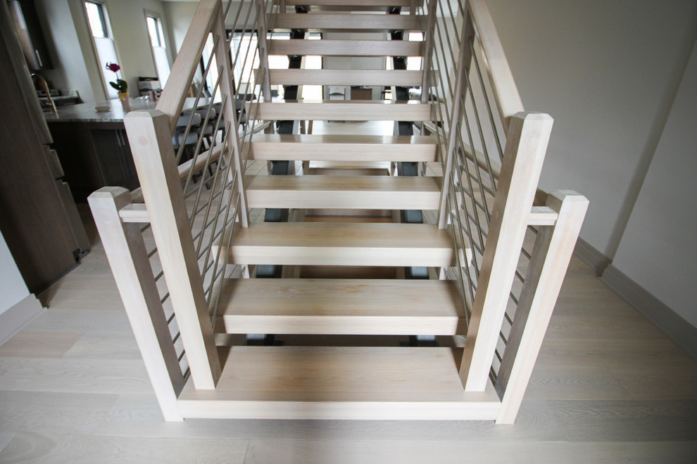 Ejemplo de escalera suspendida actual de tamaño medio con escalones de madera y barandilla de metal
