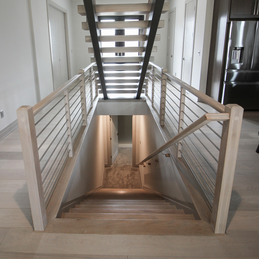 На фото: лестница на больцах, среднего размера в современном стиле с деревянными ступенями и металлическими перилами с