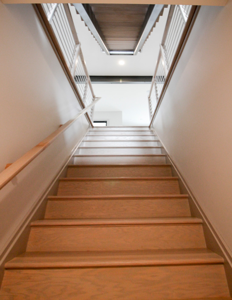 Inspiration pour un escalier flottant design de taille moyenne avec des marches en bois et un garde-corps en métal.