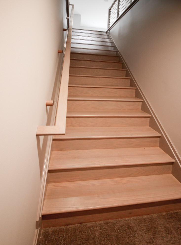 Diseño de escalera suspendida actual de tamaño medio con escalones de madera y barandilla de metal