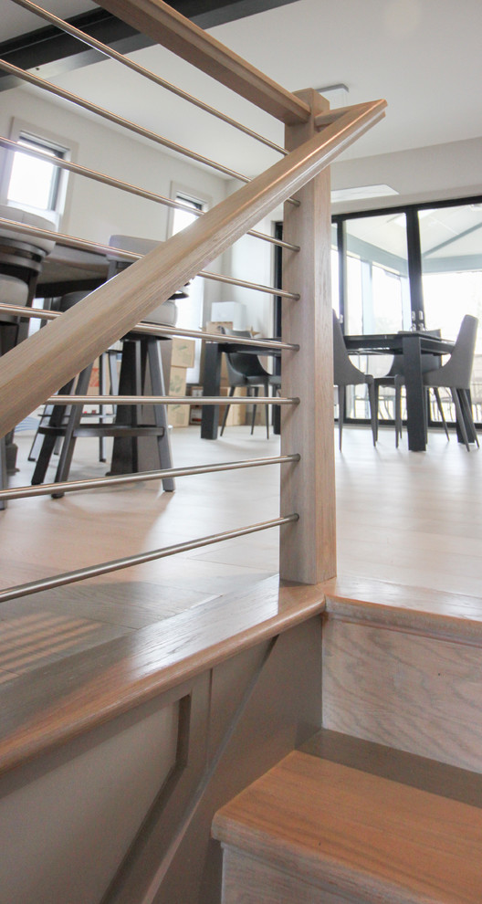 Imagen de escalera suspendida actual de tamaño medio con escalones de madera y barandilla de metal