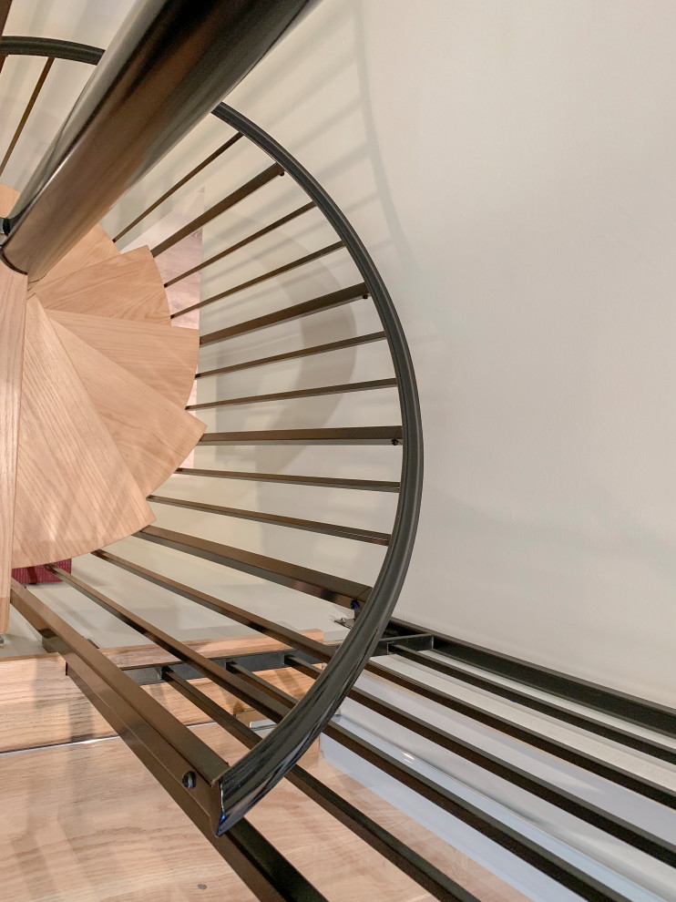 Foto di una grande scala a chiocciola contemporanea con pedata in legno, alzata in legno e parapetto in materiali misti