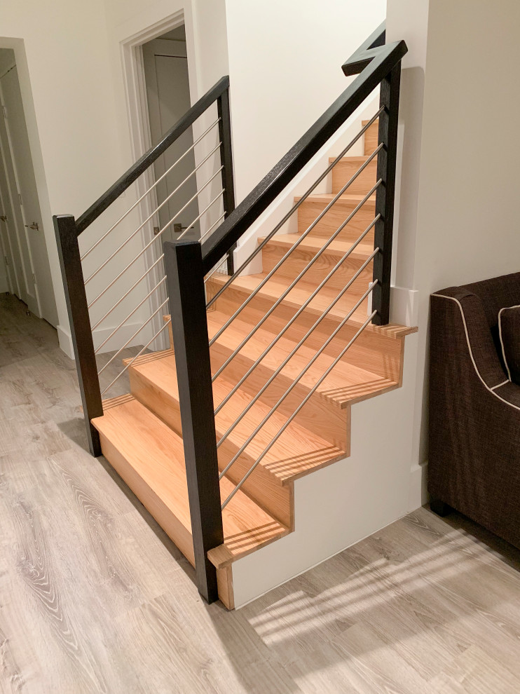 Cette photo montre un grand escalier hélicoïdal tendance avec des marches en bois, des contremarches en bois et un garde-corps en matériaux mixtes.