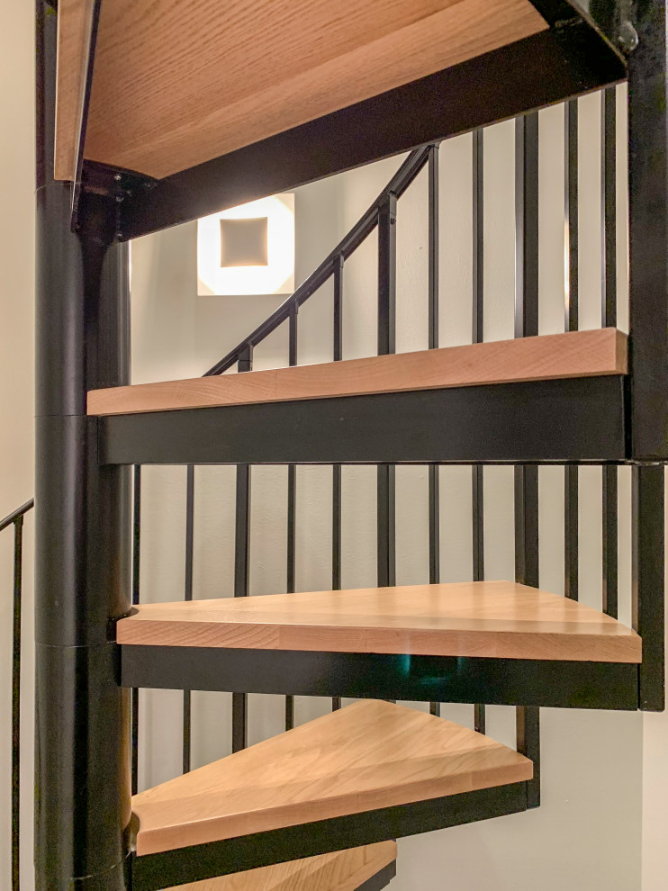 Ejemplo de escalera de caracol actual grande con escalones de madera, contrahuellas de madera y barandilla de varios materiales