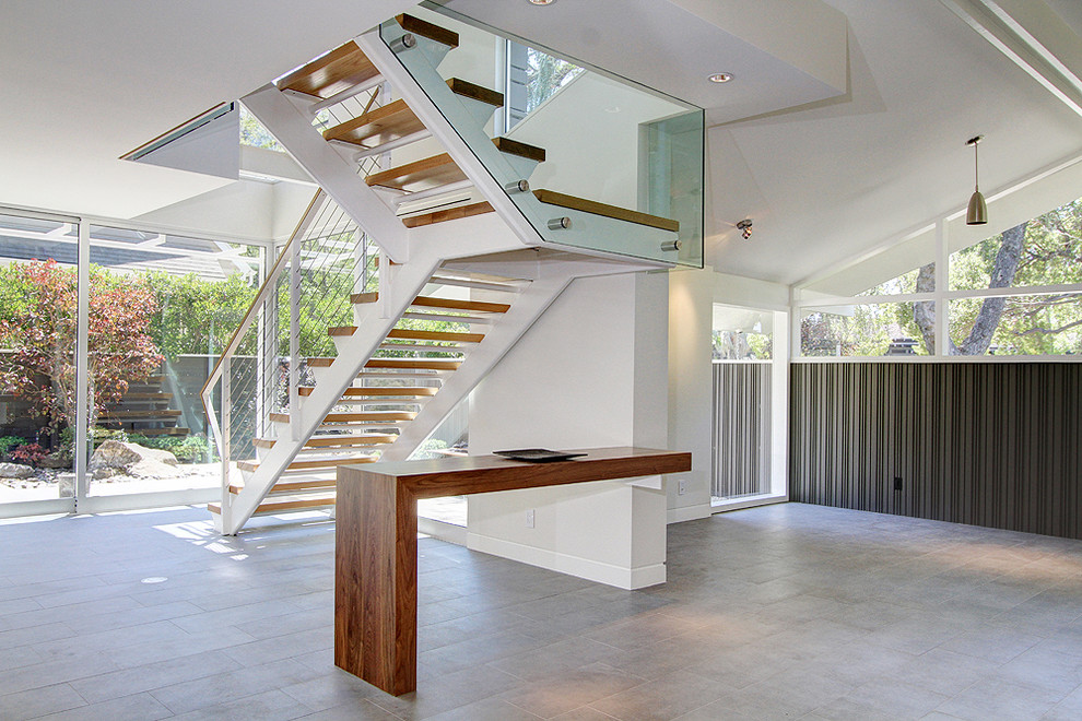 This is an example of a medium sized modern wood floating staircase in Los Angeles with open risers.