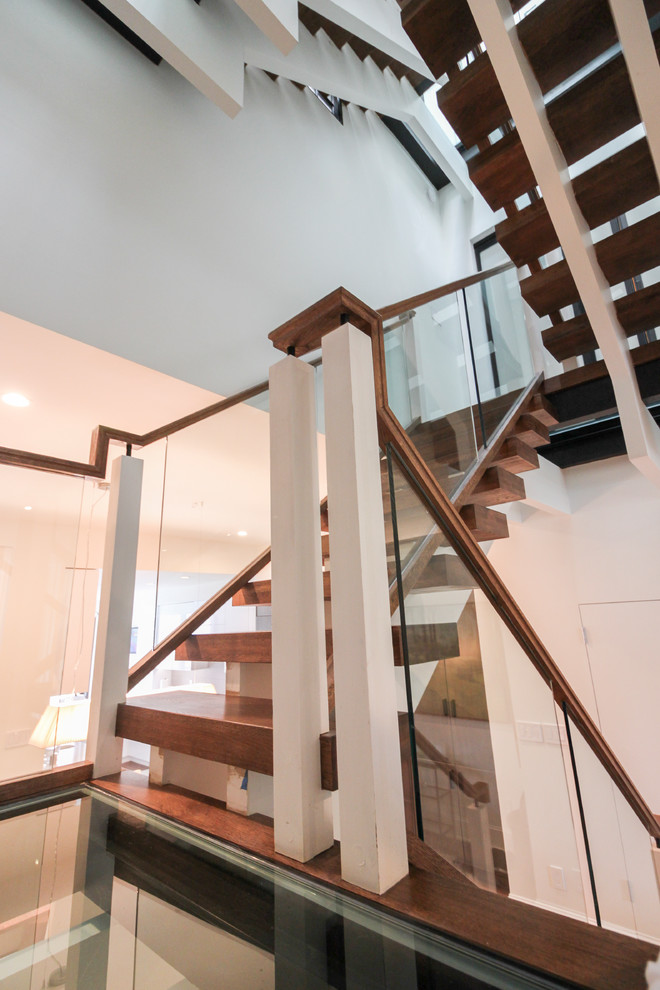 Ejemplo de escalera suspendida actual extra grande sin contrahuella con escalones de vidrio y barandilla de vidrio