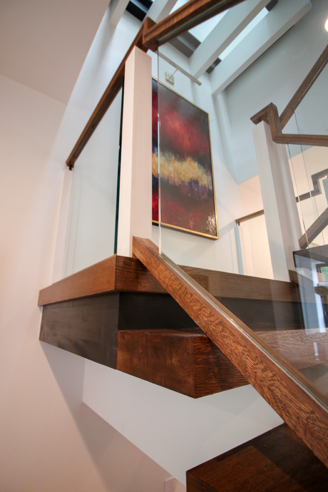 Foto på en mycket stor funkis flytande trappa i glas, med öppna sättsteg och räcke i glas