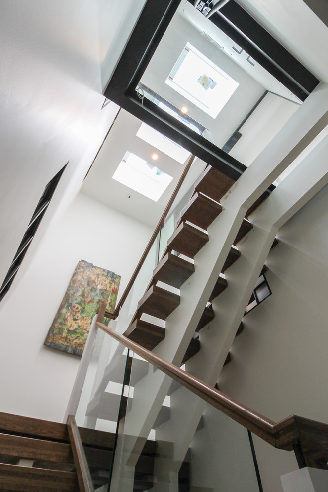 Expansive contemporary glass floating glass railing staircase in DC Metro with open risers.