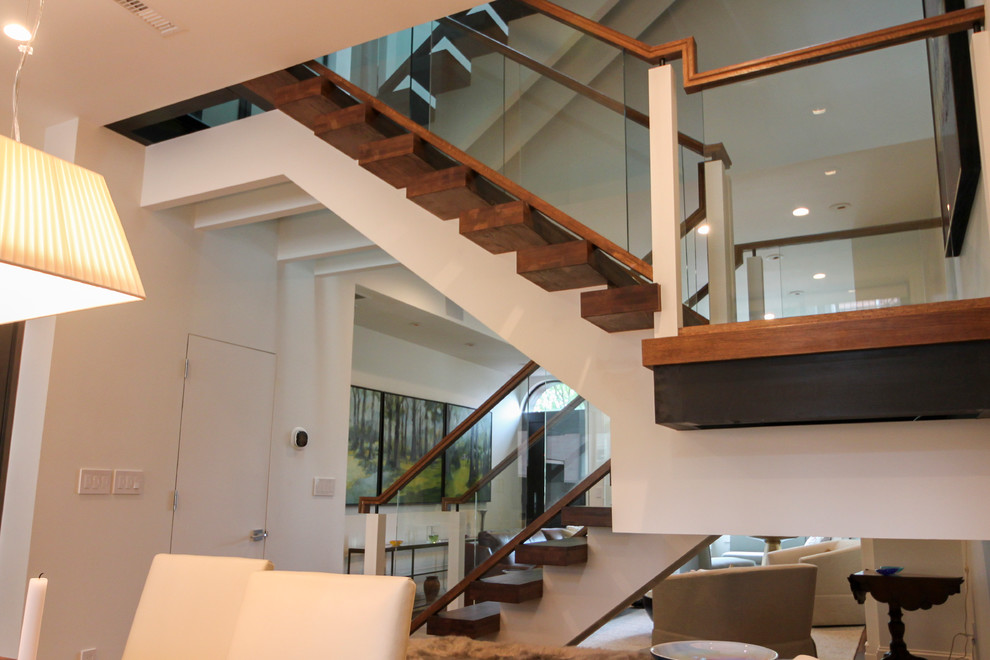 Réalisation d'un très grand escalier sans contremarche flottant design avec des marches en verre et un garde-corps en verre.