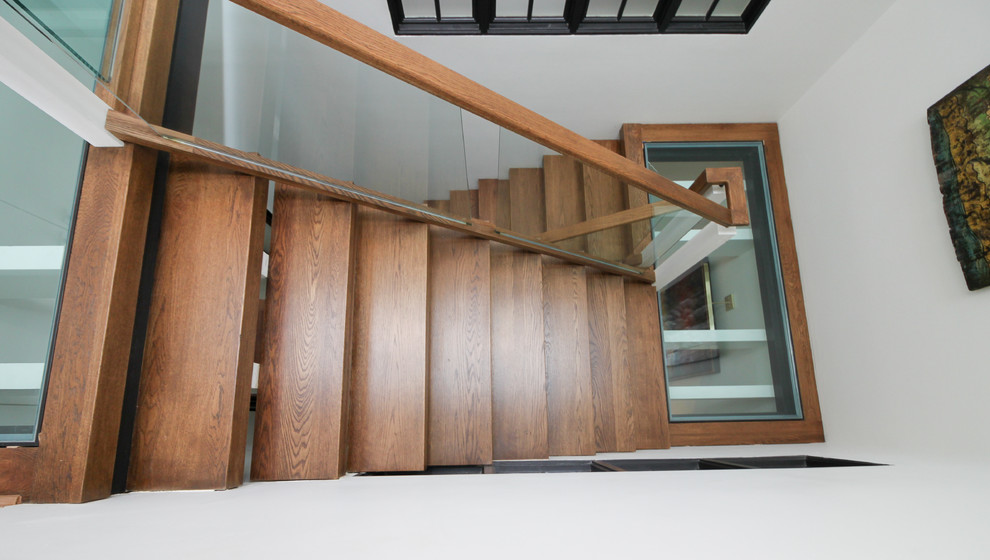 Diseño de escalera suspendida contemporánea extra grande sin contrahuella con escalones de vidrio y barandilla de vidrio