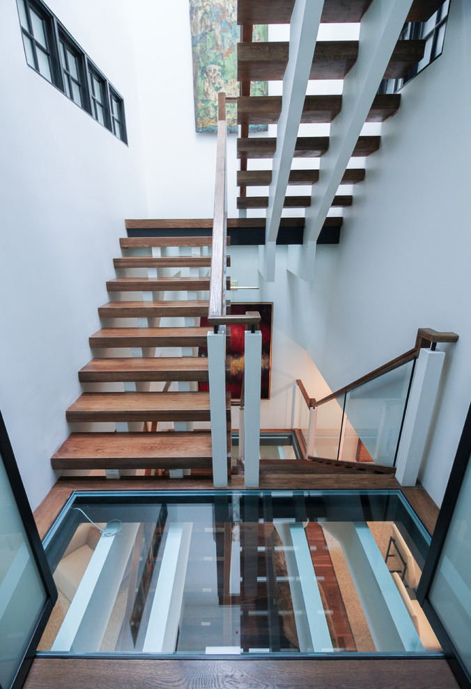 Inspiration pour un très grand escalier sans contremarche flottant design avec des marches en verre et un garde-corps en verre.