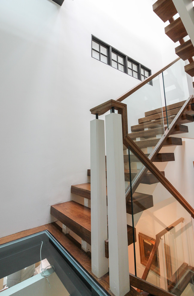 Foto de escalera suspendida actual extra grande sin contrahuella con escalones de vidrio y barandilla de vidrio