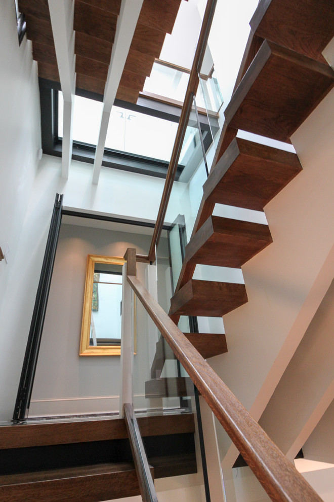 ワシントンD.C.にあるラグジュアリーな巨大なコンテンポラリースタイルのおしゃれな階段 (ガラスフェンス) の写真